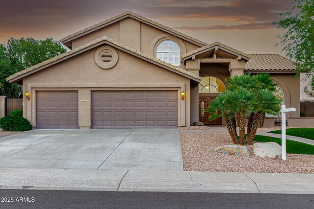 view of front of house featuring a garage, stucco siding, concrete driveway, and a tile roof