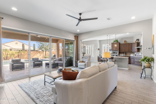 living room featuring plenty of natural light, light wood-type flooring, and ceiling fan