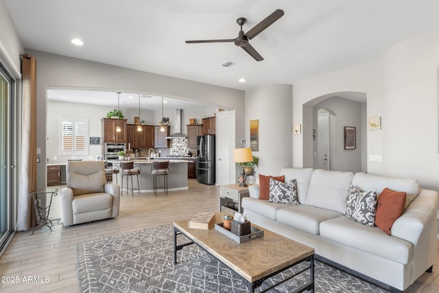 living room with light hardwood / wood-style flooring and ceiling fan