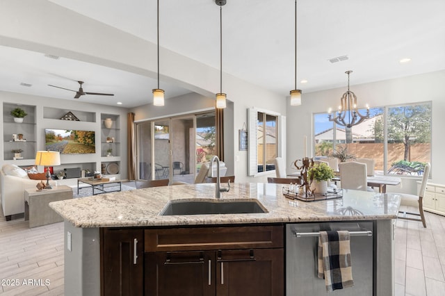 kitchen featuring dark brown cabinetry, sink, and hanging light fixtures