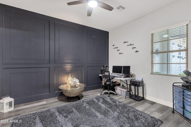 home office featuring visible vents, light wood-style flooring, ceiling fan, and baseboards