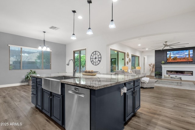 kitchen featuring light wood finished floors, dishwasher, arched walkways, ceiling fan with notable chandelier, and visible vents