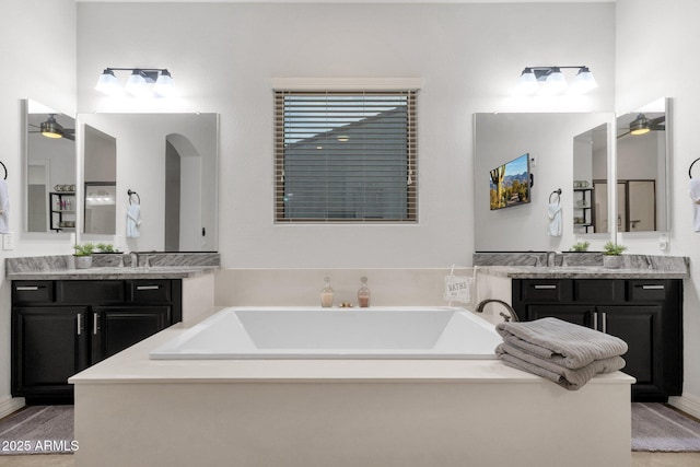 full bathroom featuring vanity, a ceiling fan, and a garden tub