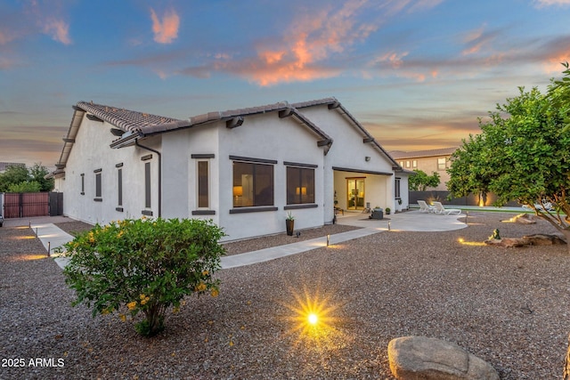 back of property with a patio, fence, and stucco siding