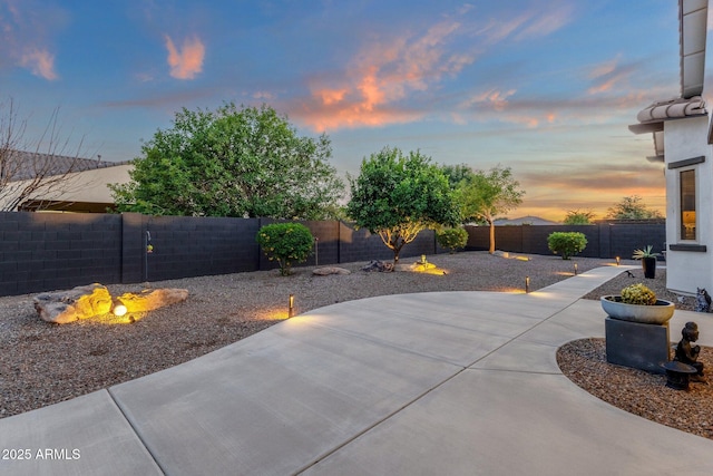 patio terrace at dusk with a fenced backyard