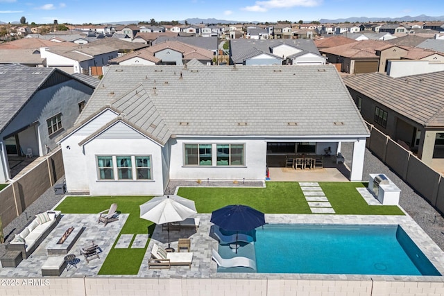 rear view of property featuring an outdoor living space with a fire pit, a fenced backyard, a residential view, a patio area, and outdoor dining space