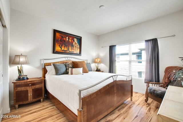 bedroom featuring light wood-style flooring and baseboards