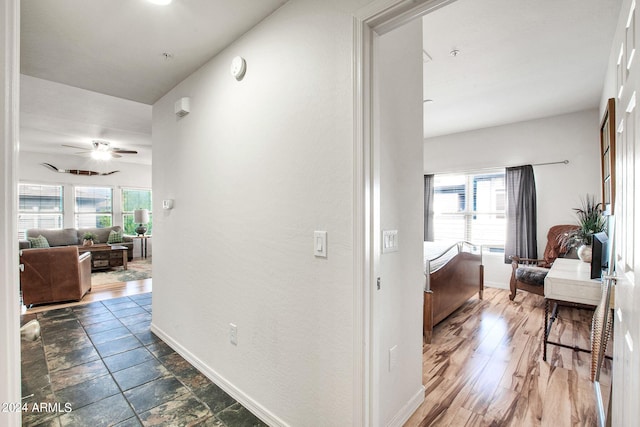 hall with baseboards and dark wood-type flooring