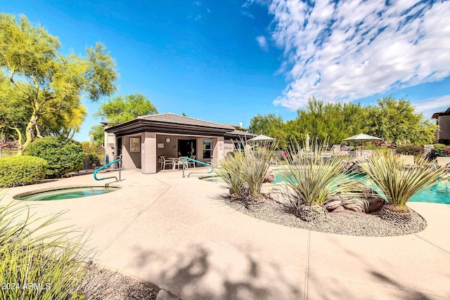 community pool featuring a patio area and a hot tub