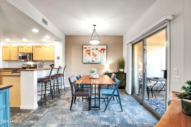 dining area with stone finish floor, recessed lighting, visible vents, and baseboards