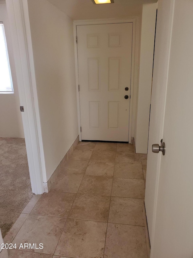 hall with light tile patterned floors