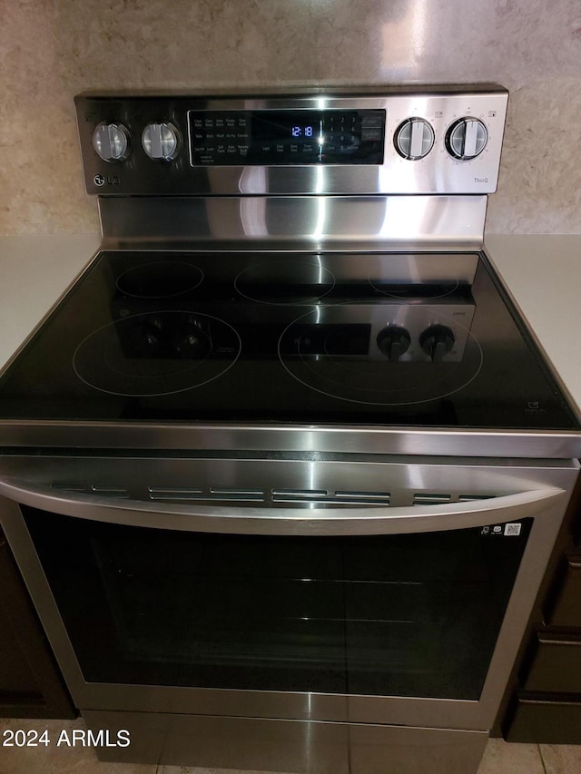 room details with light tile patterned floors and electric stove