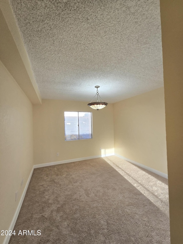 carpeted spare room featuring a textured ceiling