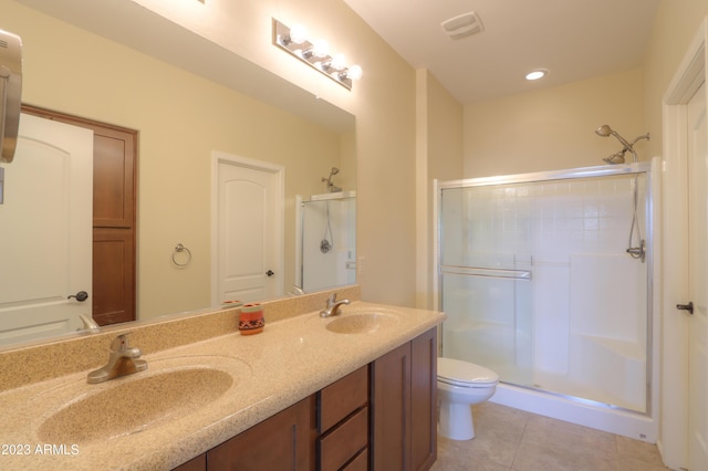 bathroom with toilet, vanity, tile patterned floors, and walk in shower