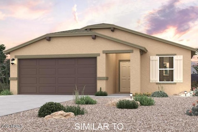 view of front facade with a garage, concrete driveway, and stucco siding