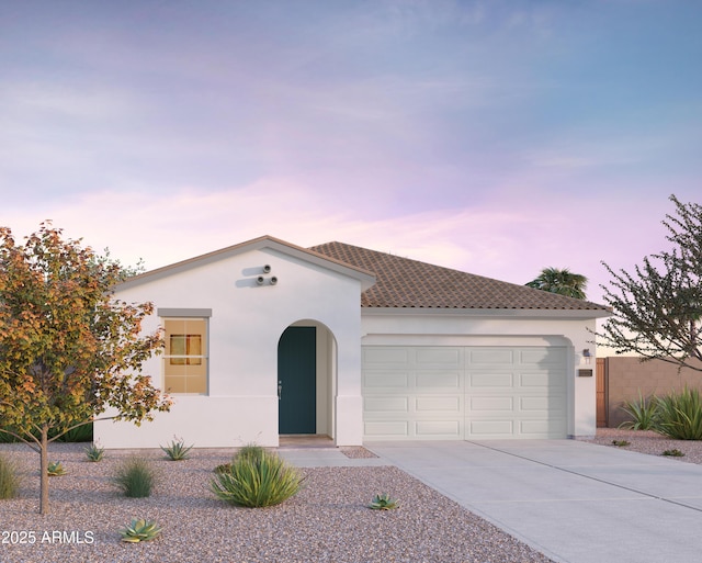 mediterranean / spanish house featuring a garage, a tiled roof, concrete driveway, and stucco siding