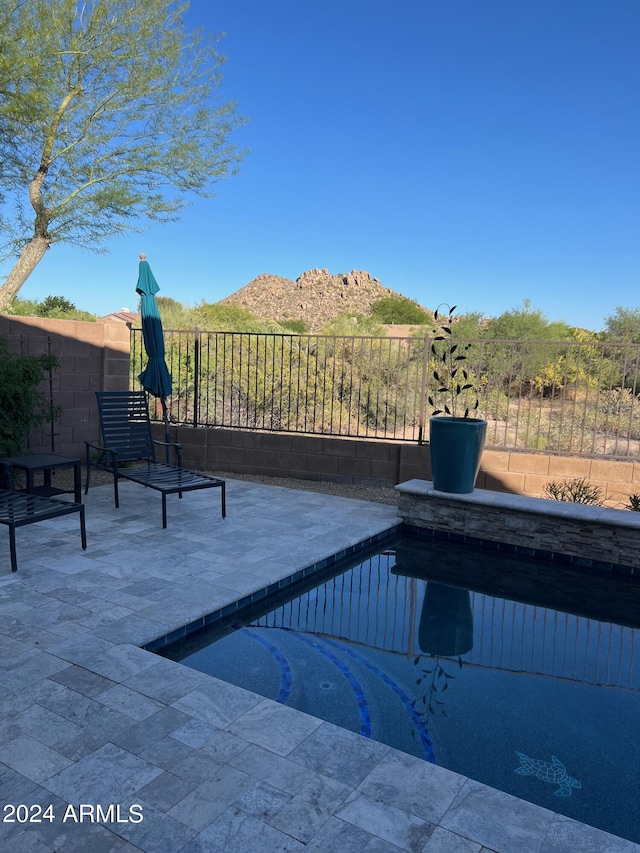 view of pool featuring a mountain view and a patio area