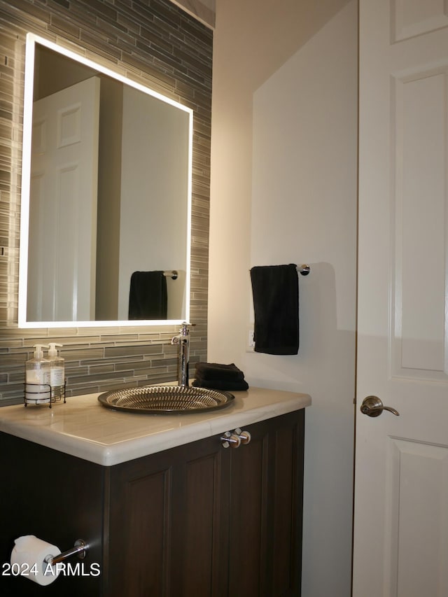 bathroom with vanity and tasteful backsplash