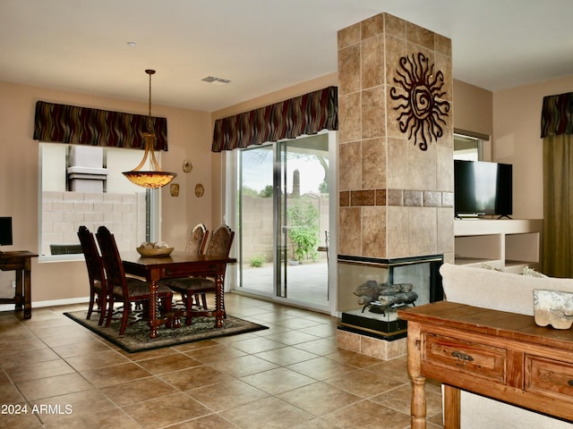 dining space with tile patterned floors and a fireplace