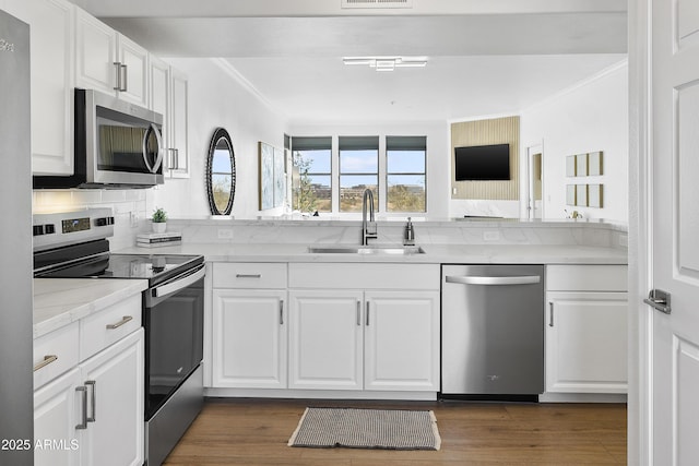 kitchen featuring light stone countertops, appliances with stainless steel finishes, backsplash, sink, and white cabinets