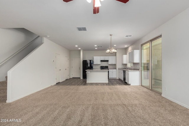 unfurnished living room featuring sink, carpet floors, and ceiling fan with notable chandelier