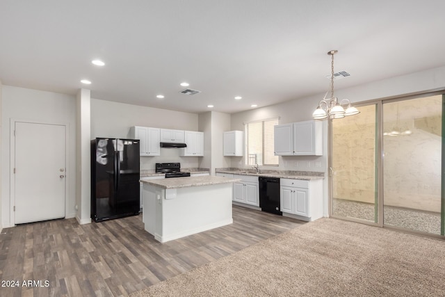 kitchen with black appliances, wood-type flooring, decorative light fixtures, white cabinets, and a center island