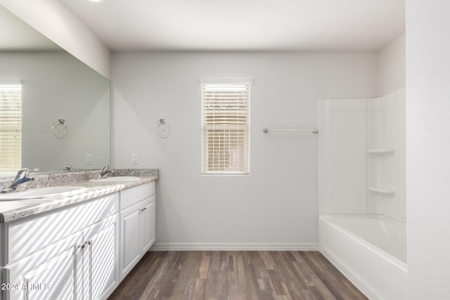 bathroom with hardwood / wood-style floors, vanity, and bathing tub / shower combination