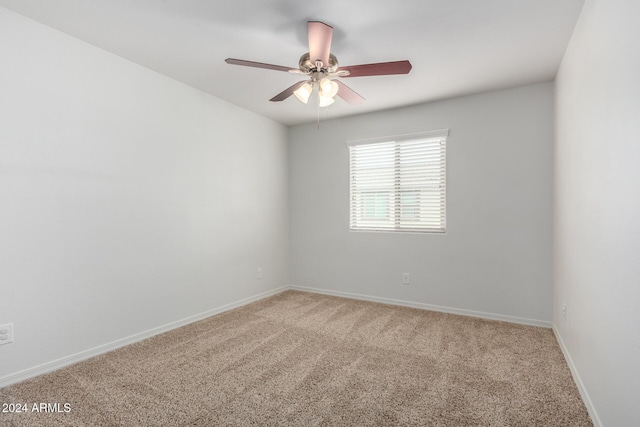 empty room featuring ceiling fan and carpet