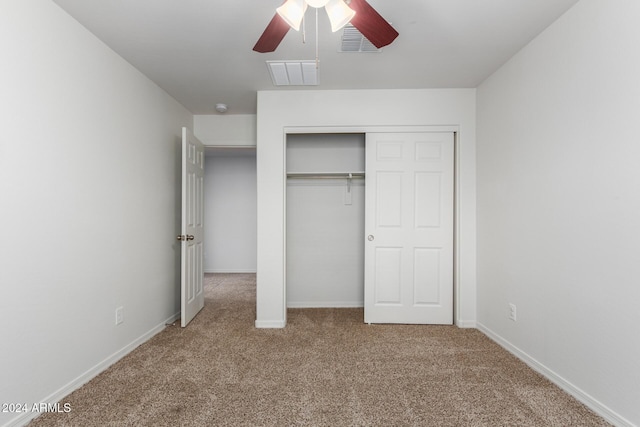 unfurnished bedroom with ceiling fan, a closet, and carpet floors