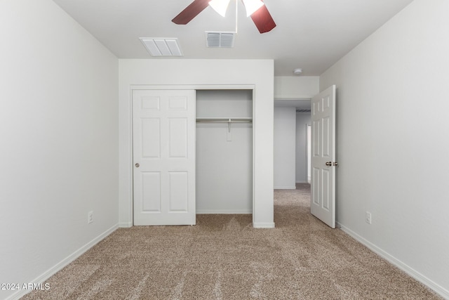 unfurnished bedroom with ceiling fan, a closet, and light colored carpet