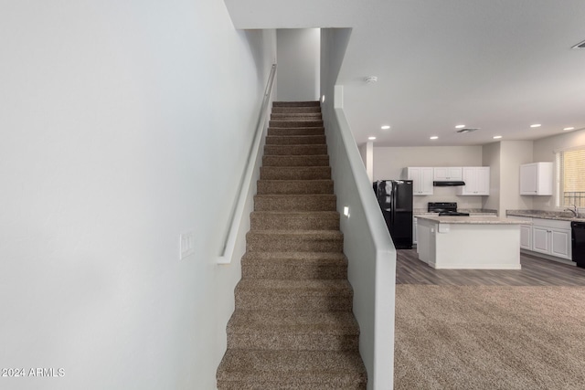 stairs with wood-type flooring and sink