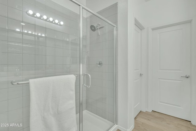 bathroom featuring hardwood / wood-style floors and a shower with shower door