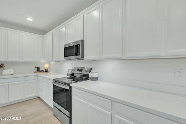 kitchen featuring white cabinetry, light hardwood / wood-style flooring, and stainless steel appliances