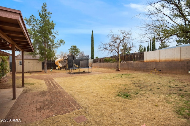 view of yard featuring a playground, a trampoline, and a storage shed