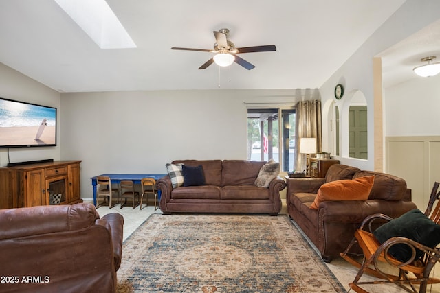 tiled living room featuring ceiling fan and a skylight