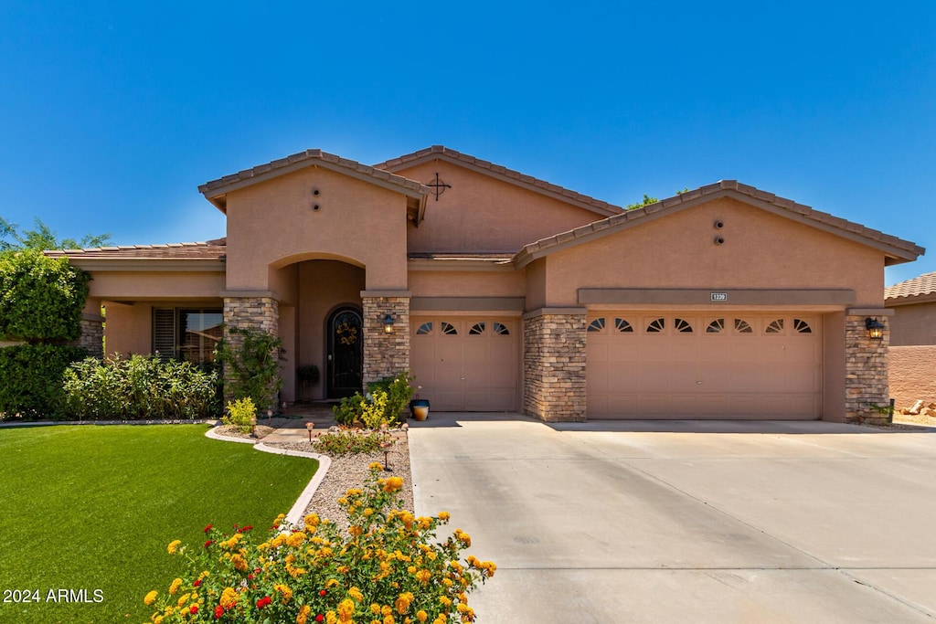 view of front of home with a garage and a front lawn