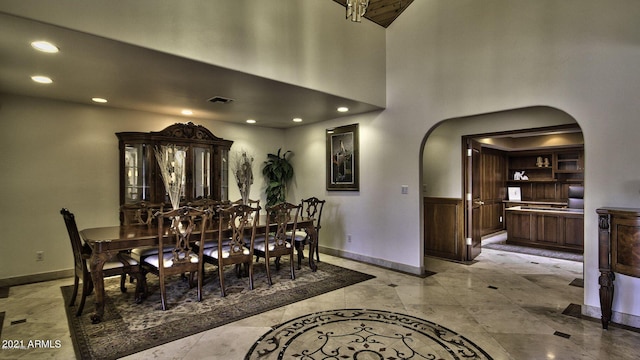 dining area with a towering ceiling