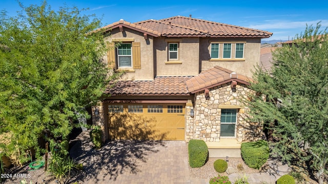 4526 E Vista Bonita Dr, Phoenix, AZ 85050 - view of front of house with decorative driveway, a garage, stucco siding, a tile roof, and stone siding