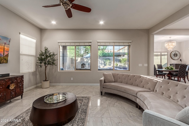 living room with ceiling fan with notable chandelier