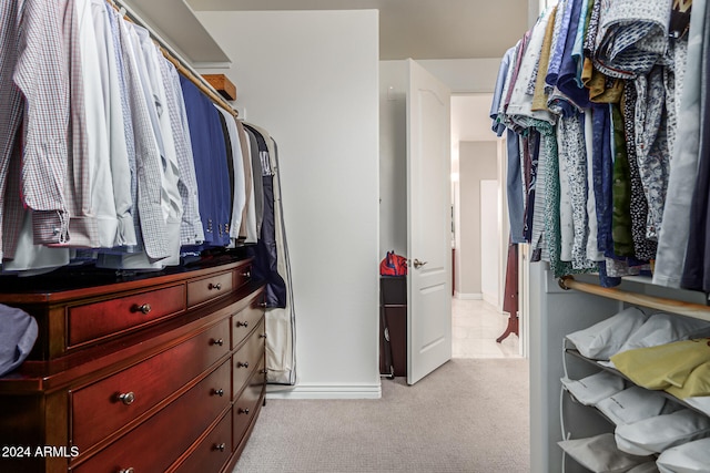 walk in closet featuring light colored carpet