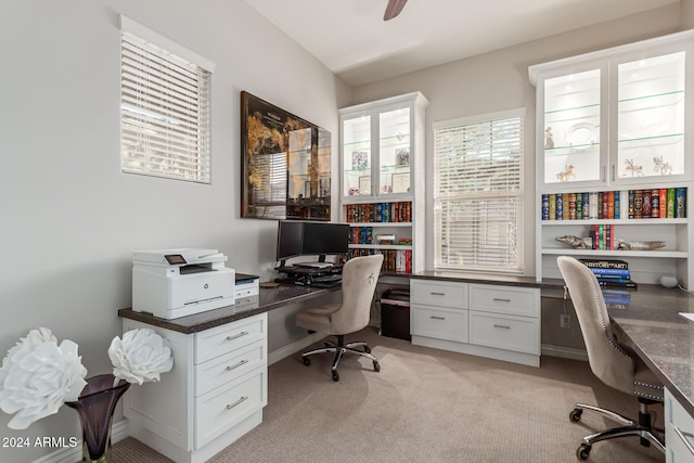 carpeted office space with ceiling fan