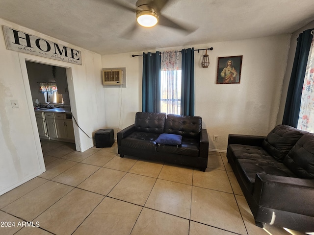 living room with a wall mounted air conditioner, light tile patterned floors, a textured ceiling, and ceiling fan