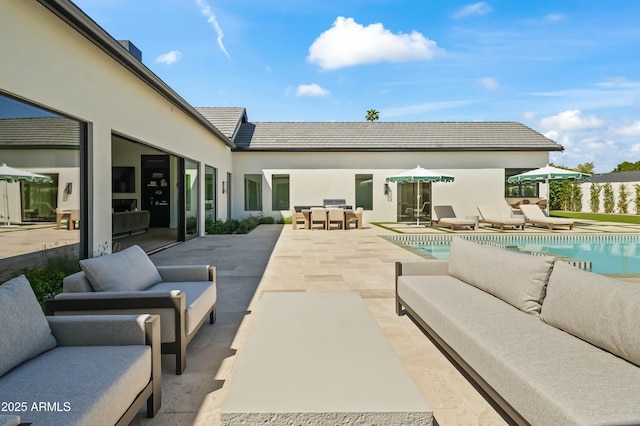 rear view of property featuring an outdoor hangout area, a patio, and an outdoor pool