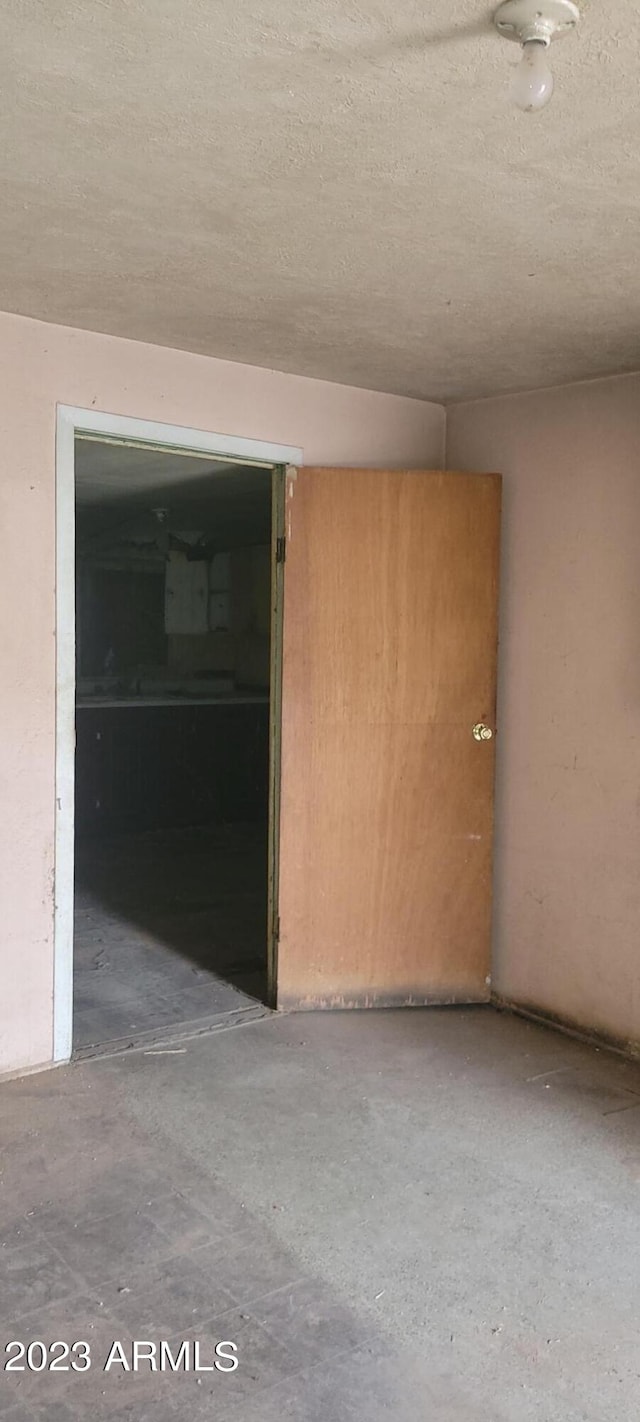 spare room featuring a textured ceiling and concrete flooring