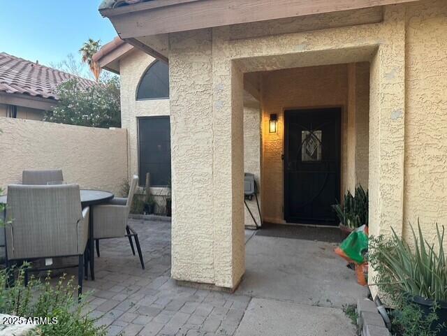 11028 W Crimson Ln, Avondale, AZ 85392 - property entrance with stucco siding, a patio, and outdoor dining space