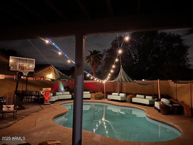 11028 W Crimson Ln, Avondale, AZ 85392 - pool at twilight featuring a patio area, a fenced backyard, and outdoor lounge area