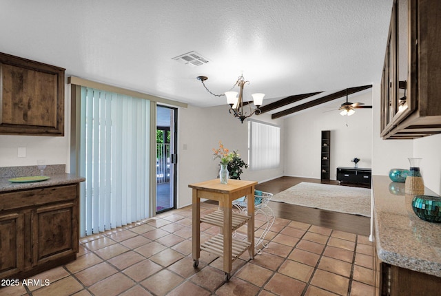 kitchen featuring dark brown cabinets, light tile patterned floors, visible vents, ceiling fan with notable chandelier, and lofted ceiling with beams