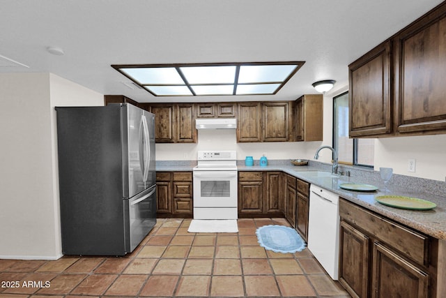 kitchen featuring a sink, white appliances, under cabinet range hood, light countertops, and dark brown cabinets