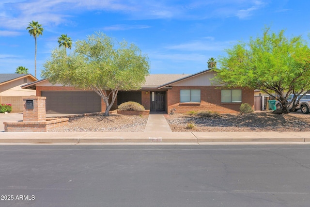 single story home featuring concrete driveway, brick siding, and an attached garage