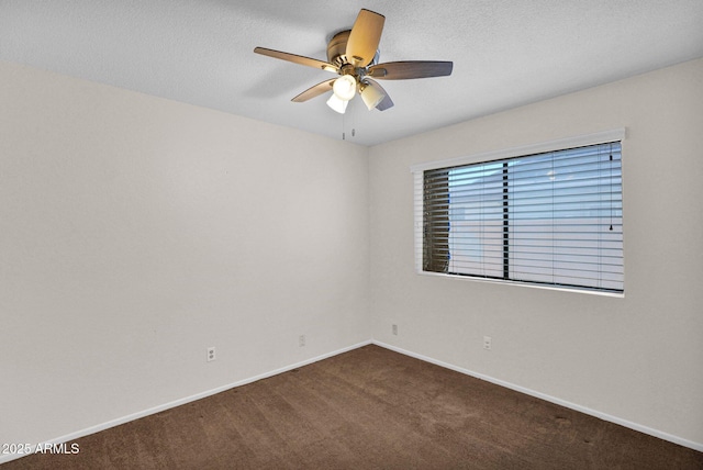 carpeted empty room with ceiling fan and baseboards